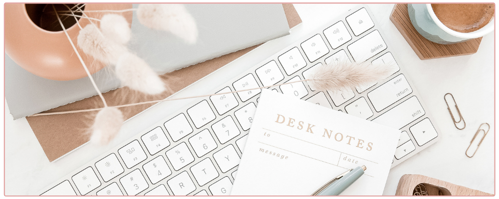 Keyboard and note pad on the desk of a female entrepreneur in the business suite.