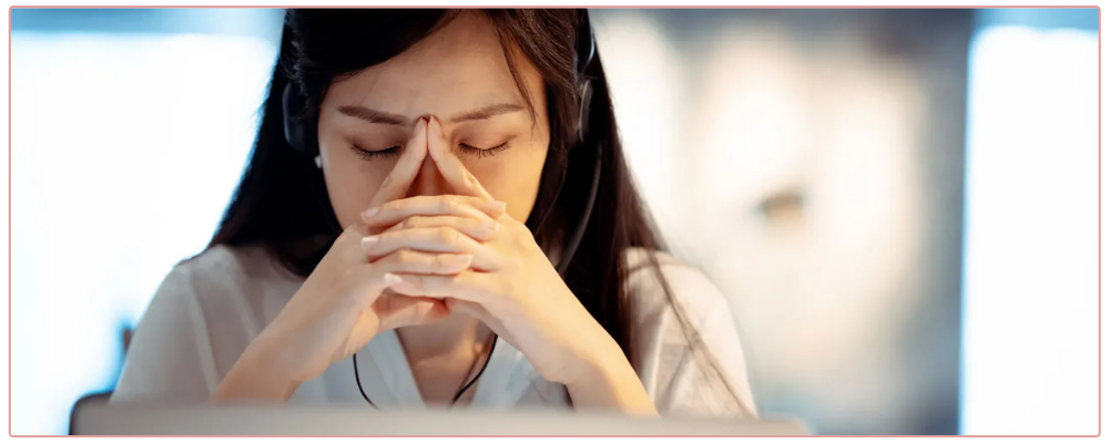 Woman at her desk feeling overwhelmed.