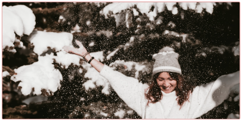 Woman throwing snow up in the air - living her best life.